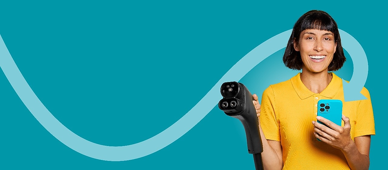 Woman in a yellow shirt holding a charging cable and her smartphone – symbol of charging with the Shell App.