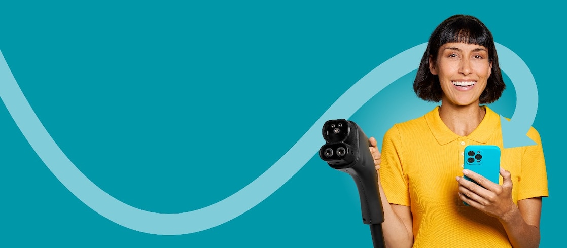 Woman in a yellow shirt holding a charging cable and her smartphone – symbol of charging with the Shell App.